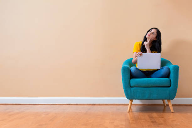 istock Young woman with a laptop computer in a thoughtful pose 1185978773