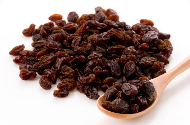 istock Dried raisins in a wooden spoon 1185980016