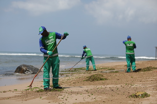 salvador, bahia / brazil - October 13, 2019: Cleaning agents withdraw oil from Pituba Beach, the site was affected by oil spills at sea.