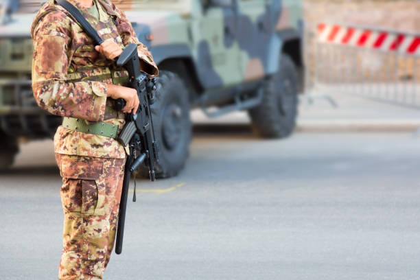 żołnierz z karabinem we włoskim mundurze w pobliżu wojskowego suv-a opancerzonego samochodu. - security barrier zdjęcia i obrazy z banku zdjęć