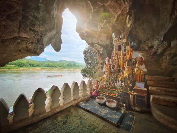 Pak Ou Cave Buddhas Laos Mekong River Sunbeam into the Pak Ou Cave Buddha Shrine at Tham Ting Buddhist Cave. Pak Ou, Mekong River, Luang Prabang, Laos, Southeast Asia. laos photos stock pictures, royalty-free photos & images