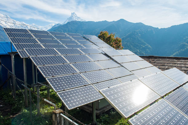 Solar cell panels installation on the high mountains in Annapurna sanctuary of Nepal with Machapuchare mountain at the background. Solar cell is an electrical device that converts the energy of light directly into electricity by the photovoltaic effect. annapurna range photos stock pictures, royalty-free photos & images