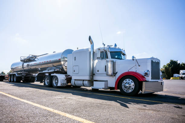 istock White classic big rig semi truck with tank semi trailer for transporting liquid cargo standing on truck stop parking lot 1185998872