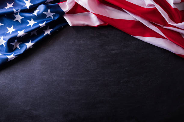 istock Happy Veterans Day. American flags veterans against a blackboard background. 1186002261