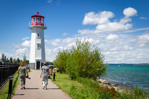 istock two caucasian women on vacation walking toward a lighthouse. 1186006986