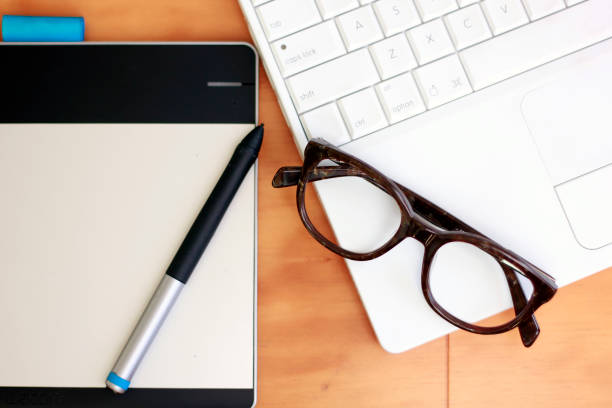 istock Eyeglasses, tablet and laptop in a desktop 1186008326