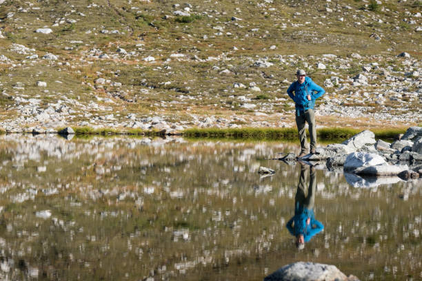 istock Male hiker with backpack looking at the view over the lake 1186010232