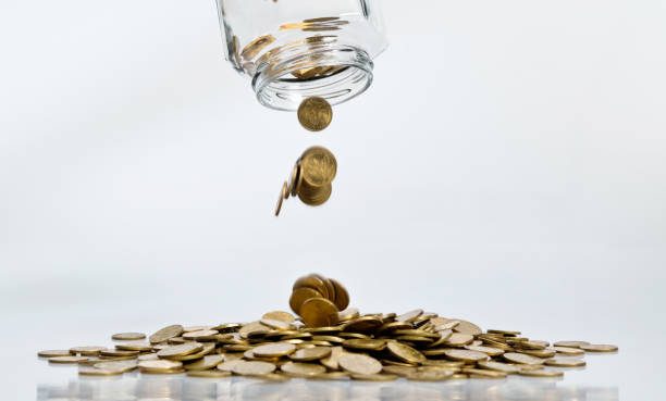 istock Coins pouring from a glass jar 1186018678