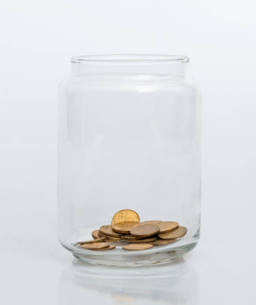 istock Coins in glass jar on white background 1186020724