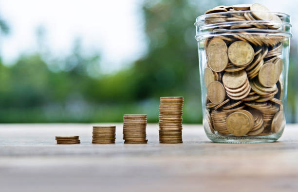 istock Coin stairs and jar on wooden table 1186021547