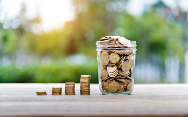 istock Coin stairs and jar on wooden table 1186021561