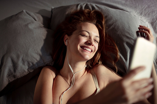 Close up of a young lady using her phone to listen to music