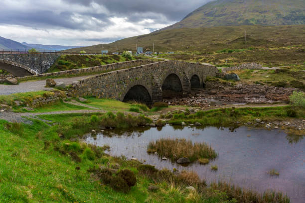 An old Sligachan bridge situated at the junction of the roads from Portree, Dunvegan and Broadford , provides a good viewpoint for seeing the Black Cuillin mountains ,  Isle of Skye, Scotland An old Sligachan bridge situated at the junction of the roads from Portree, Dunvegan and Broadford , provides a good viewpoint for seeing the Black Cuillin mountains ,  Isle of Skye, Scotland isle of skye broadford stock pictures, royalty-free photos & images