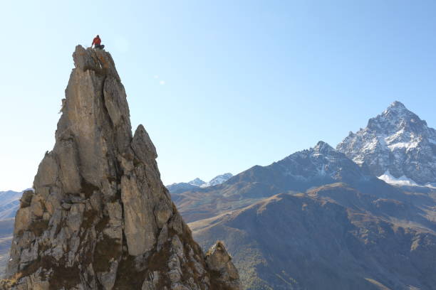 istock Female mountaineer ascends to mountain summit 1186035085
