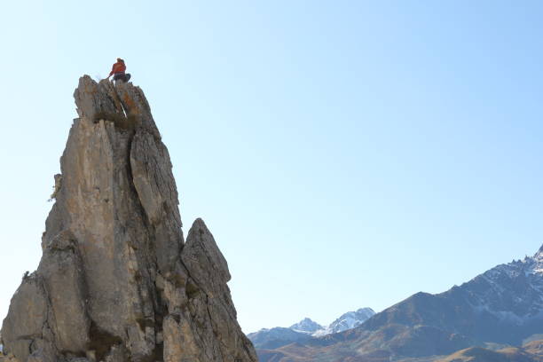 istock Female mountaineer ascends to mountain summit 1186035164