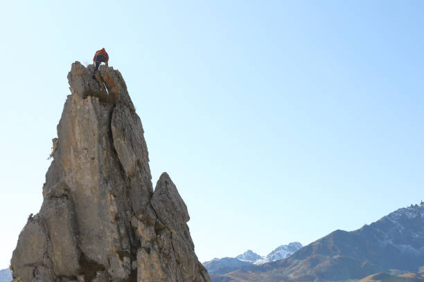istock Female mountaineer ascends to mountain summit 1186035196