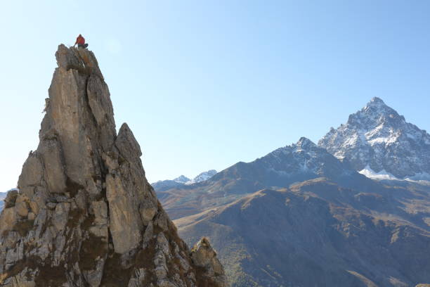 istock Female mountaineer ascends to mountain summit 1186036358