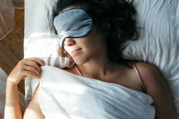 istock woman sleeping in mask in bed bright light on face morning time 1186036496