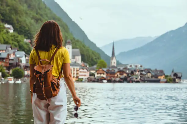 woman standing on the beach looking at hallstatt city copy space