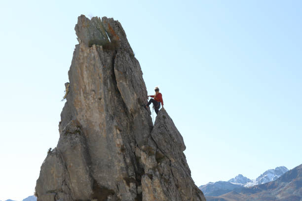istock Female mountaineer ascends to mountain summit 1186036615