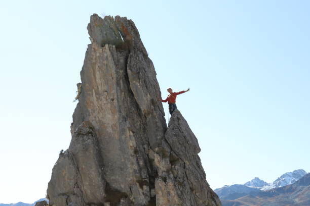 istock Female mountaineer ascends to mountain summit 1186036921