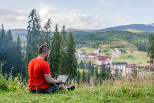 istock Remote work concept: a man working on a laptop outdoors. Work during the holidays, workaholic. Freelance 1186036984