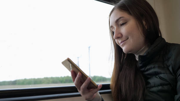 istock Young woman is watching something on smartphone travelling by train. 1186039166