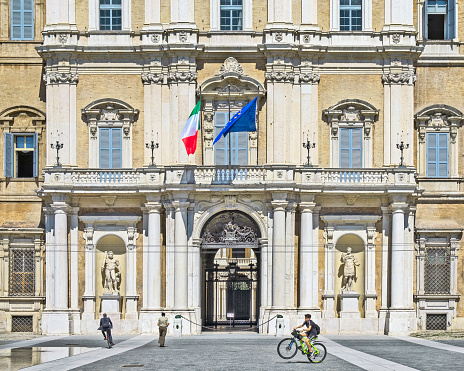 Modena, Italy - September 04, 2019: The main entrance to the military academy in Modena, Italy with cyclists and a pedestrian.