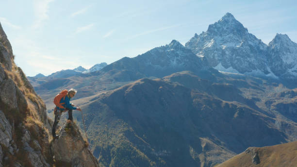 istock Mountaineer relaxes on mountain slope 1186044207
