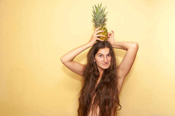 istock Girl with pineapple on her head 1186044596