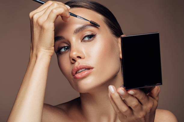 женщина, применяя макияж - women mirror human eye human face стоковые фото и изображения