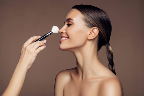 beautiful young woman applying foundation powder - brushing women make up ceremonial makeup imagens e fotografias de stock