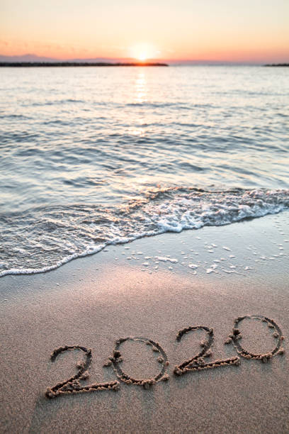 istock New year 2020 handwritten on the sandy beach with waves 1186049891