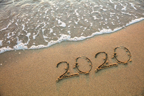 istock New year 2020 handwritten on the sandy beach with waves 1186050855