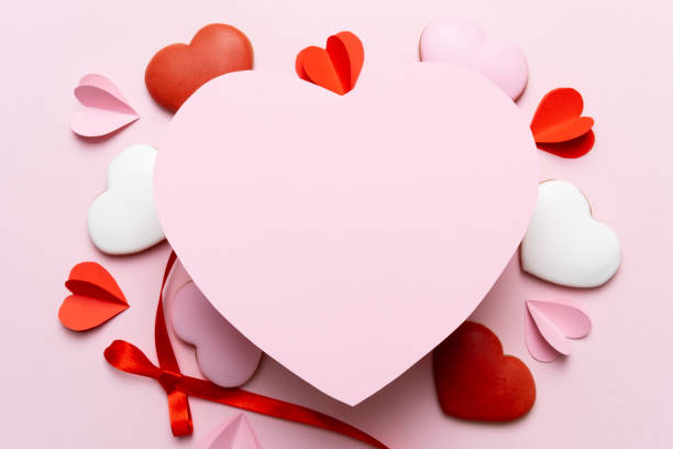Valentine's Day background of gifts, candles, confetti on pink background.