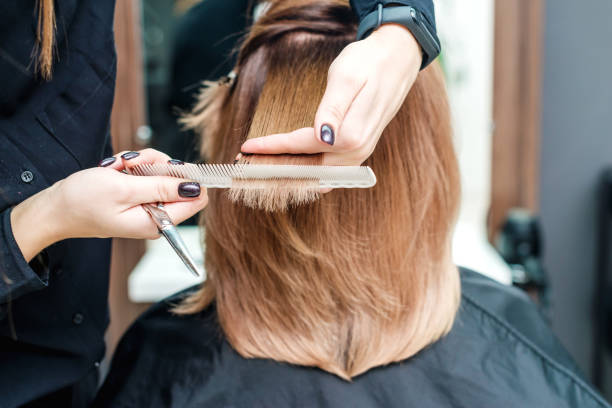 hairdresser's hands are holding red hair in the beauty salon. - hairstyle imagens e fotografias de stock