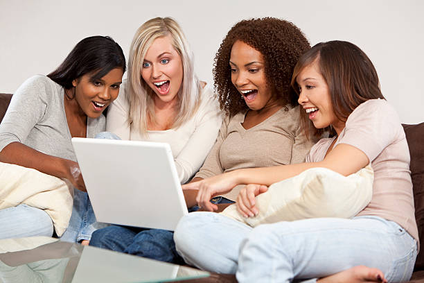 istock Four Interracial Female Friends Laughing and Looking at Laptop Computer 118605324