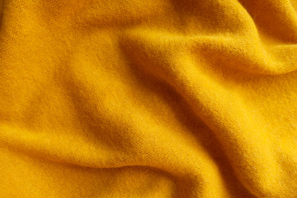 istock Orangey yellow knitted woolen fabric in soft folds 1186061727
