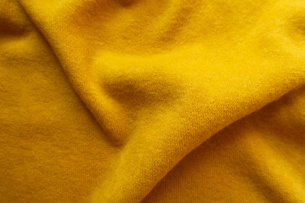 istock Yellow knitted woolen fabric in soft folds 1186061757