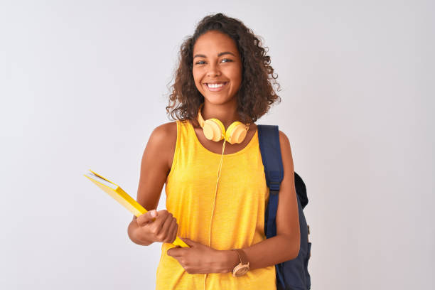brazilian student woman wearing backpack holding notebook over isolated white background with a happy face standing and smiling with a confident smile showing teeth - teenager teenagers only one teenage girl only human face imagens e fotografias de stock