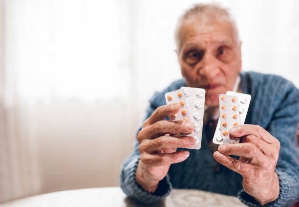 istock Elderly man holding pills 1186065308