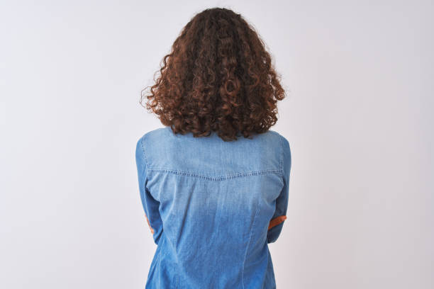 Young brazilian woman wearing denim shirt standing over isolated white background standing backwards looking away with crossed arms Young brazilian woman wearing denim shirt standing over isolated white background standing backwards looking away with crossed arms dipping photos stock pictures, royalty-free photos & images