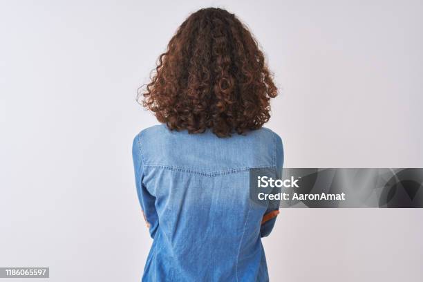 Young Brazilian Woman Wearing Denim Shirt Standing Over Isolated White Background Standing Backwards Looking Away With Crossed Arms Stock Photo - Download Image Now