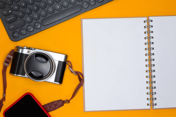 istock Travel concept with camera keyboard note and smartphone on orange background 1186066797