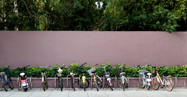 много велосипедов парковка на обочине дороги - bicycle rack стоковые фото и изображения