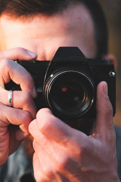 istock Close-up view of a black SLR camera in hands. 1186070263