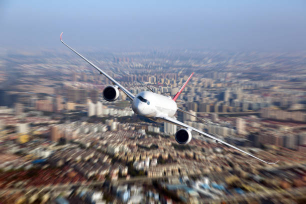istock Modern passenger aircraft flyes above the city 1186070828