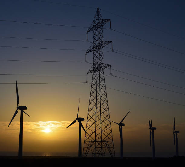 istock Wind turbines and high voltage tower 1186072218