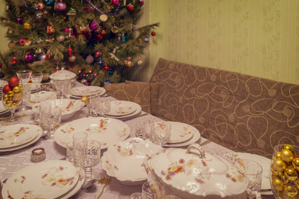 istock Served table with festive tableware near beautiful decorated Christmas tree in living room interior. Concept of new year holiday at cozy home. Vintage tone 1186072247