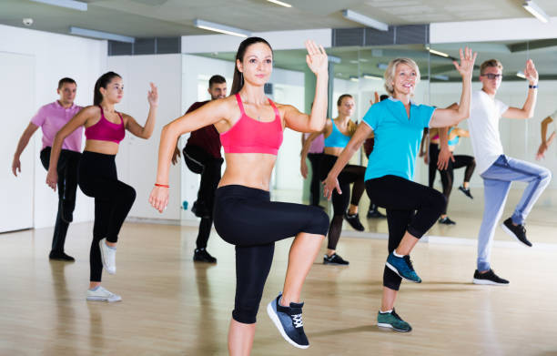 People training at dance class Smiling people of different ages studying zumba dance elements in dancing hall curtseying stock pictures, royalty-free photos & images